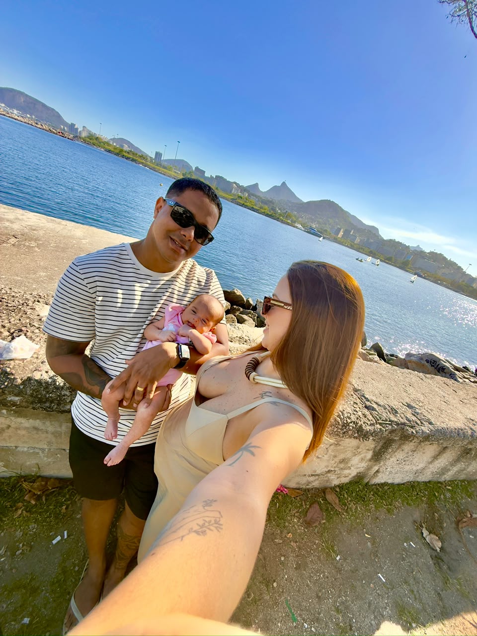 Maria Luiza passeando com os pais diante da lagoa